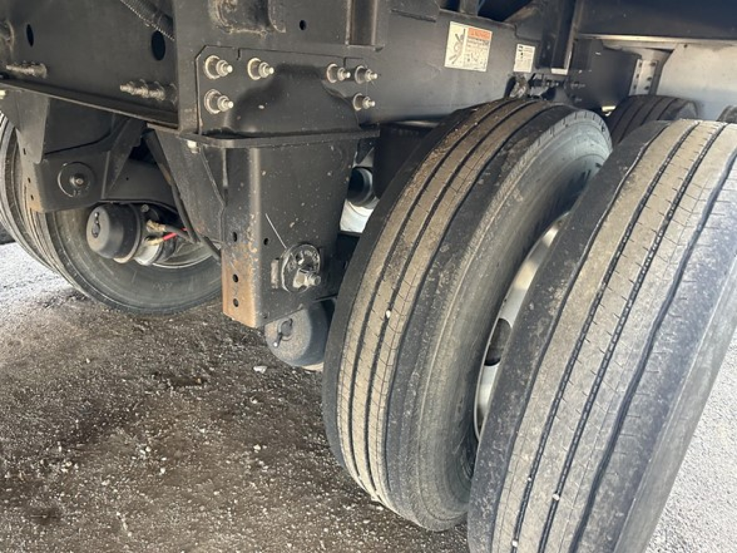 Trailer wheel assembly and undercarriage showing tandem axles and mounted suspension on a 2025 Wilson 42' air ride grain trailer with 79" sides.