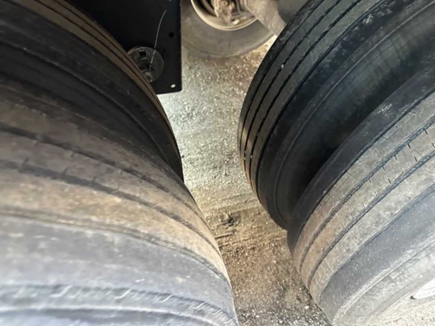 Trailer wheel drums showing dual rear axles with dual tires, tread visible, in-service condition.