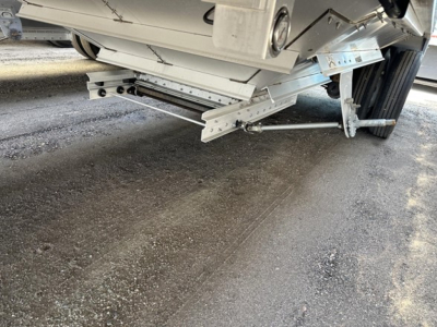 Trailer undercarriage of a Wilson 42' air ride grain trailer showing suspension linkage and side railing, visible 79" side height label on body.