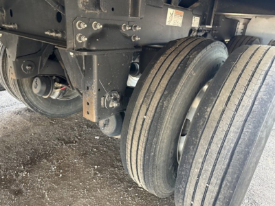 Trailer wheel assembly and undercarriage showing tandem axles and mounted suspension on a 2025 Wilson 42' air ride grain trailer with 79" sides.
