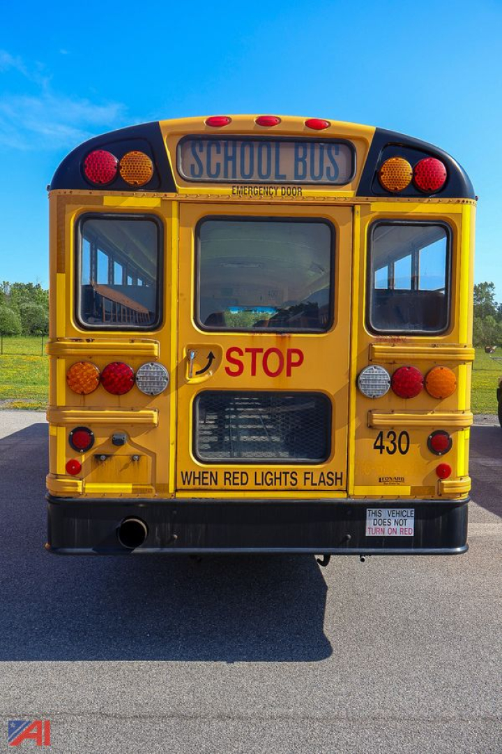 Rear view of a yellow IC Corporation CE Series school bus with 'STOP' sign and various lights, bus number 430, and 'WHEN RED LIGHTS FLASH' sticker.