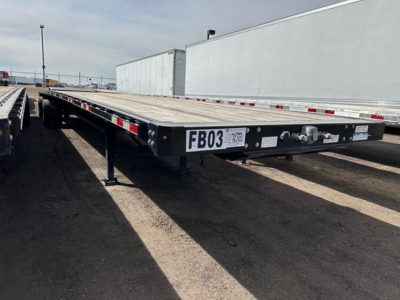 Flatbed trailer showing FB03 label and front coupling area with electrical plug and frame rail details.