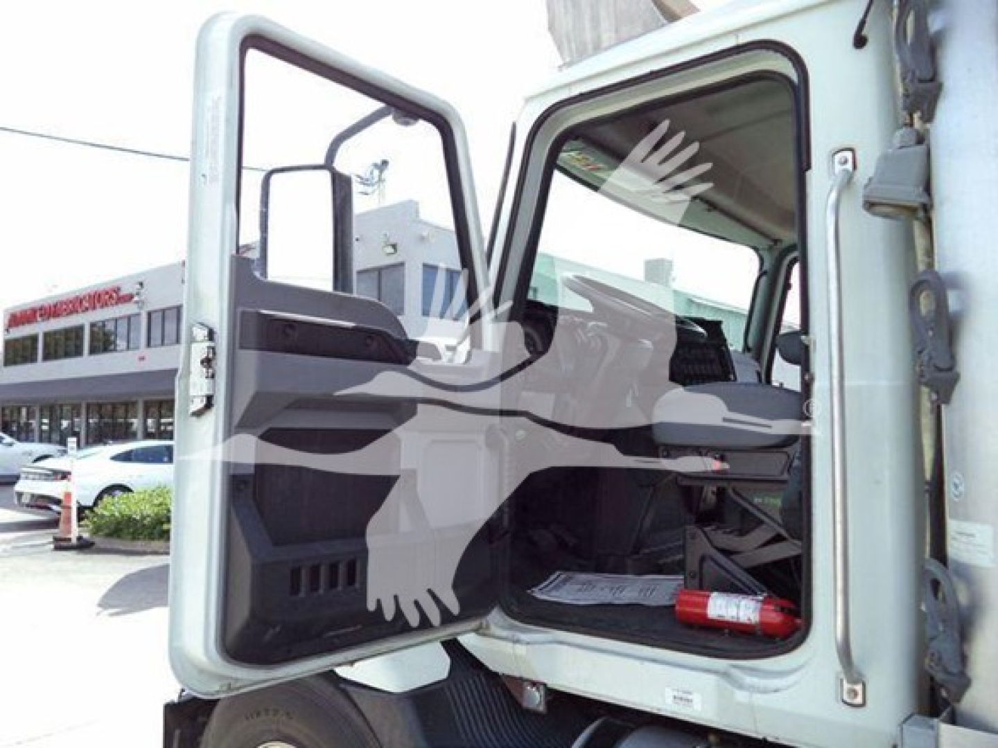 Mack MD6 truck cab interior visible through open door showing steering wheel dash area and passenger seat.