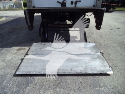 Flatbed/rear view of a refrigerated Mack MD6 truck with lift platform extended, showing metal ramp/platform and undercarriage components.
