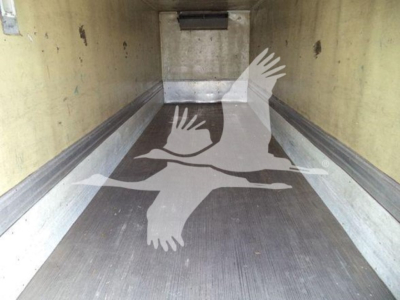 Truck trailer cargo area interior showing empty refrigerated trailer with metal floor and side walls.