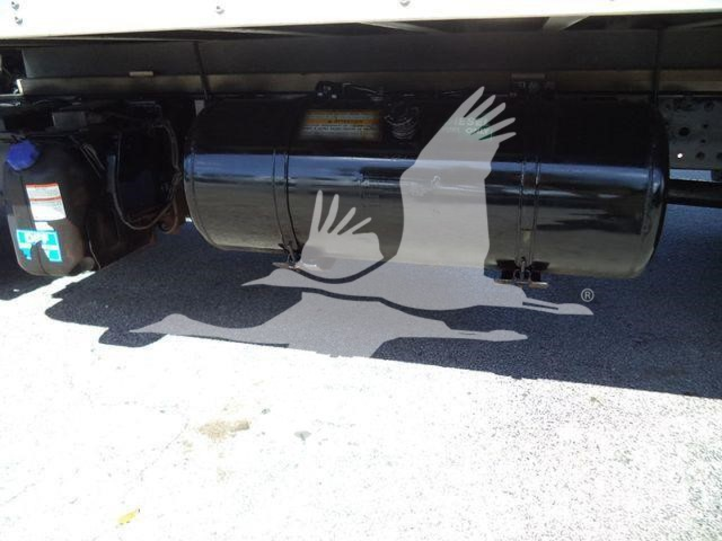 Underbody tank and components of a 2020 Hino 195, showing a cylindrical fuel/wuel tank with black finish and adjacent blue-cap reservoir or filter housing.