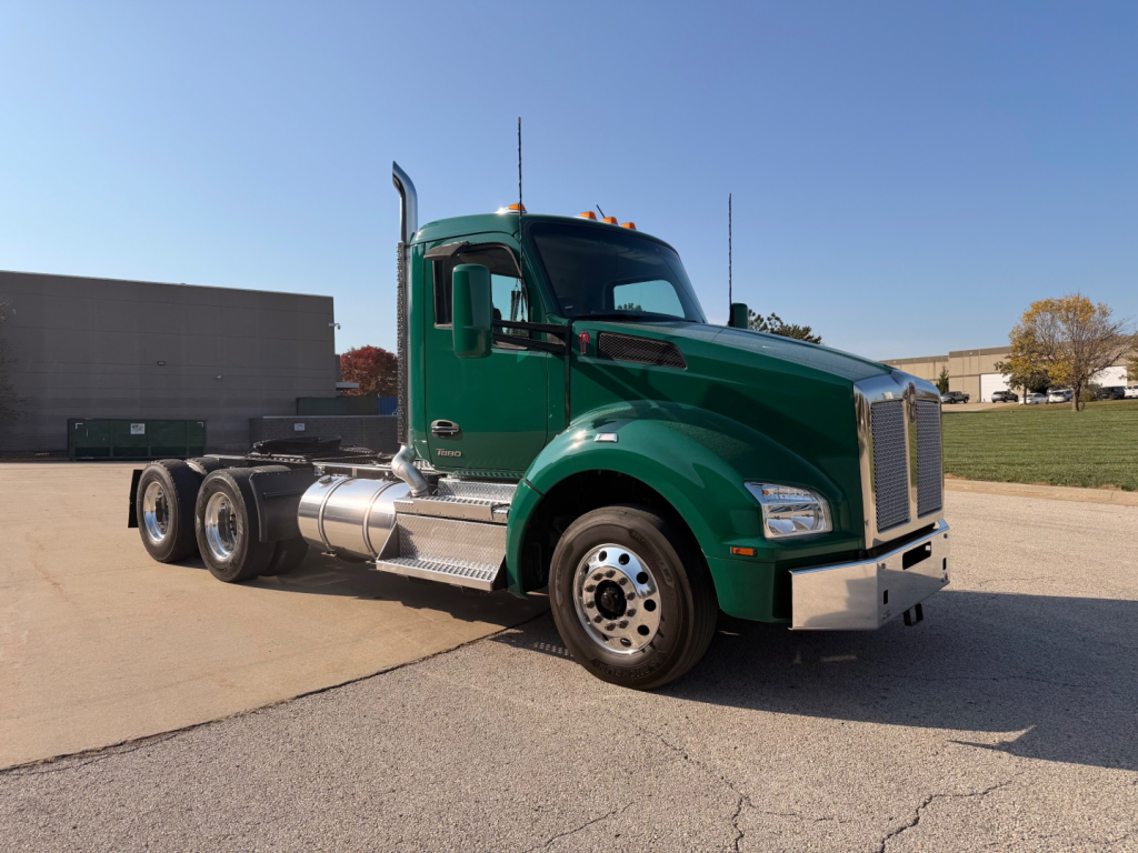 Kenworth T880 semi-truck cab and chassis in green, front 3/4 view, fuel tanks and chrome bumper visible.
