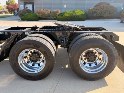 Kenworth T880 chassis side showing dual rear axles with large chrome wheels and tires; no cab visible, trailer hitch area and frame overhead.