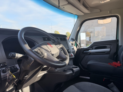 Kenworth T880 truck interior dash and steering wheel view from driver seat showing steering wheel, instrument cluster, center console, and passenger seat.