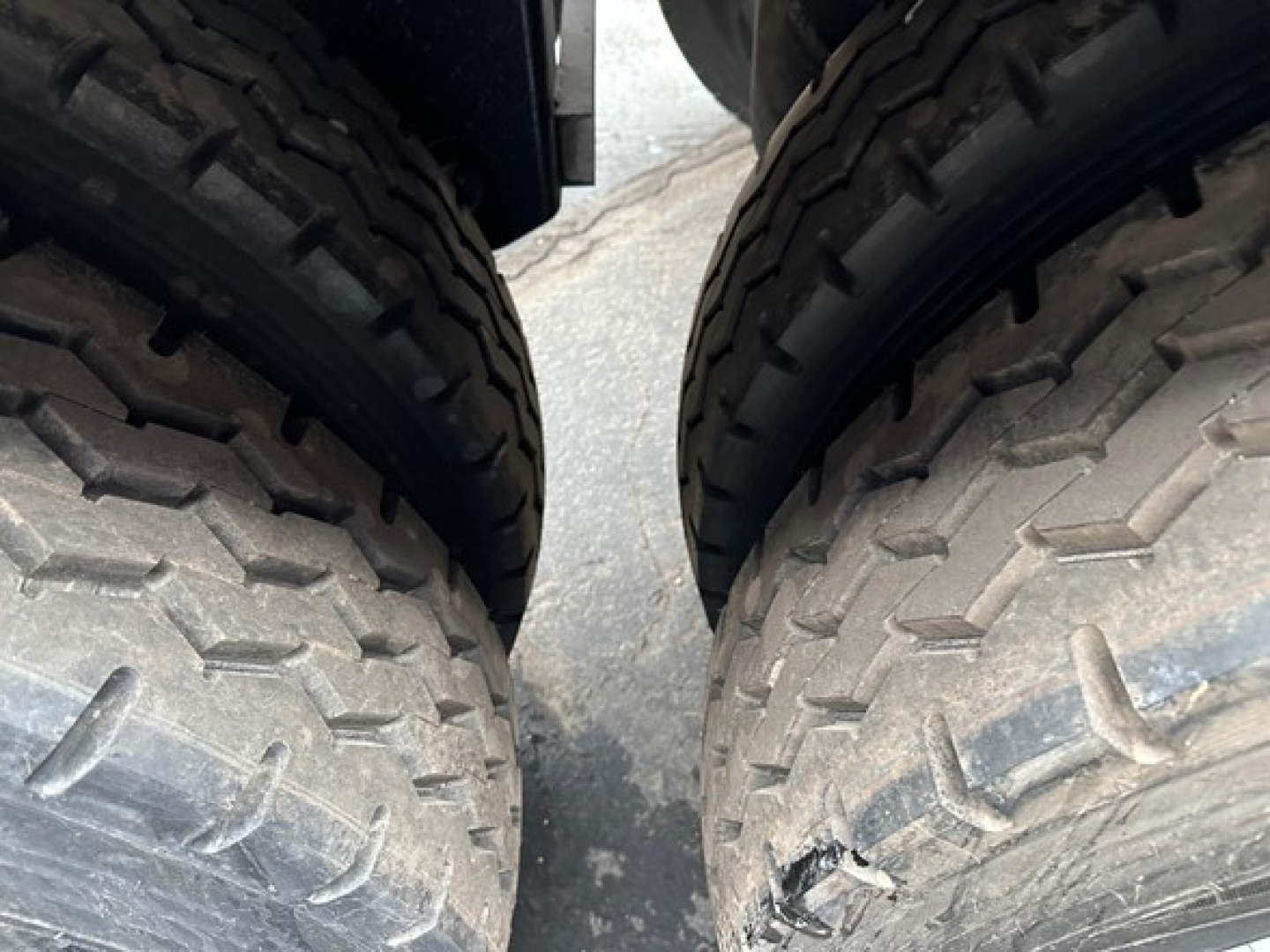 Two heavy-duty trailer tires in close-up view showing tread pattern and sidewalls.