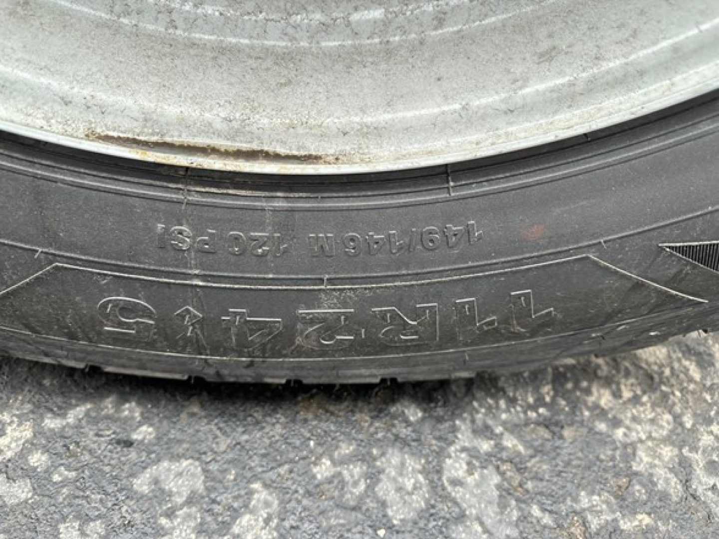 Truck trailer wheel showing tire text and markings visible on sidewall.