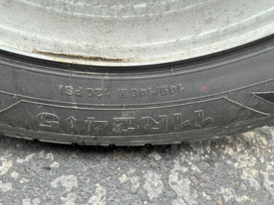 Truck trailer wheel showing tire text and markings visible on sidewall.