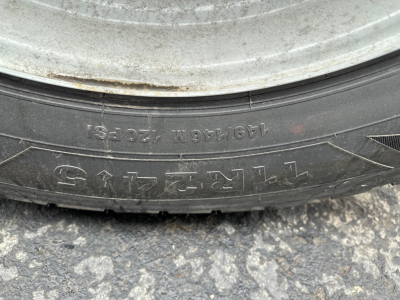 Tire sidewall with numbers and letters including 13 0Z? N? and 4??; tire tread and rim visible