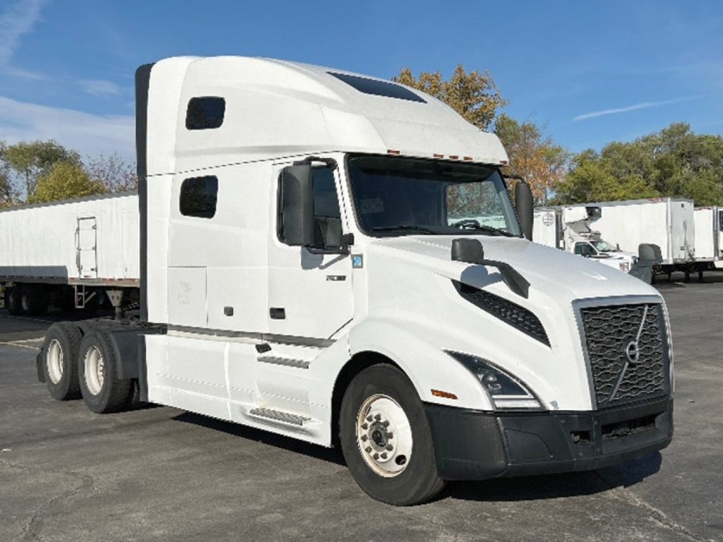 Truck side show Volvo VNL 760 sleeper cab with white paint and black bumper; visible text on cab and wheel area