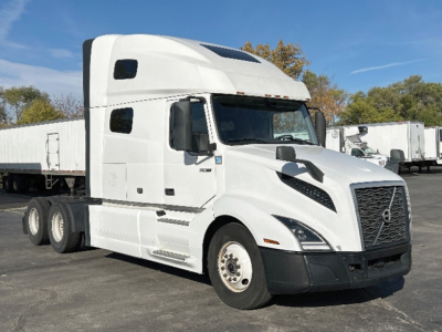 Truck side show Volvo VNL 760 sleeper cab with white paint and black bumper; visible text on cab and wheel area