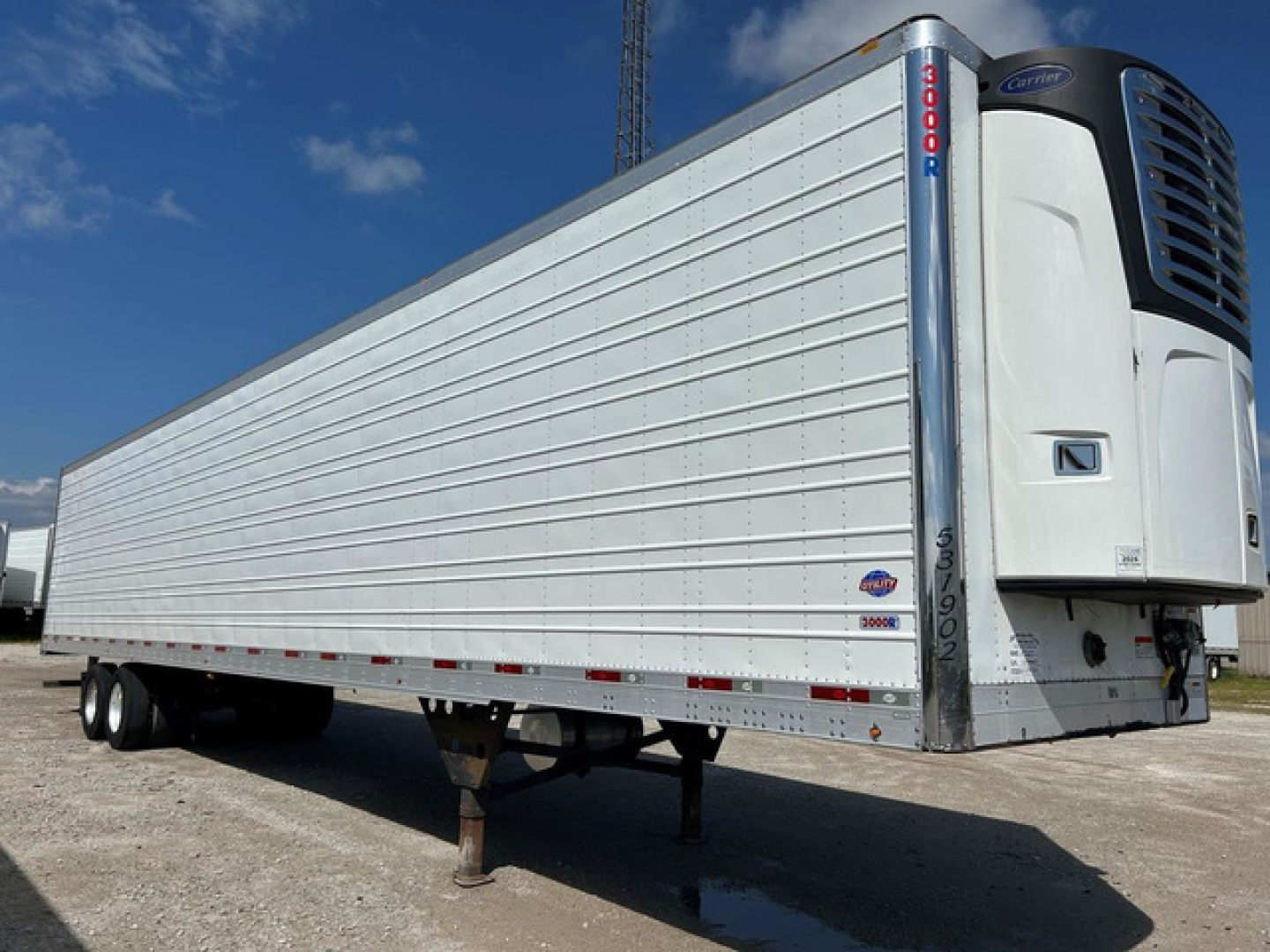 Refrigerated trailer showing Thermo King reefer unit at front, white corrugated sides, truck trailer with landing legs down.