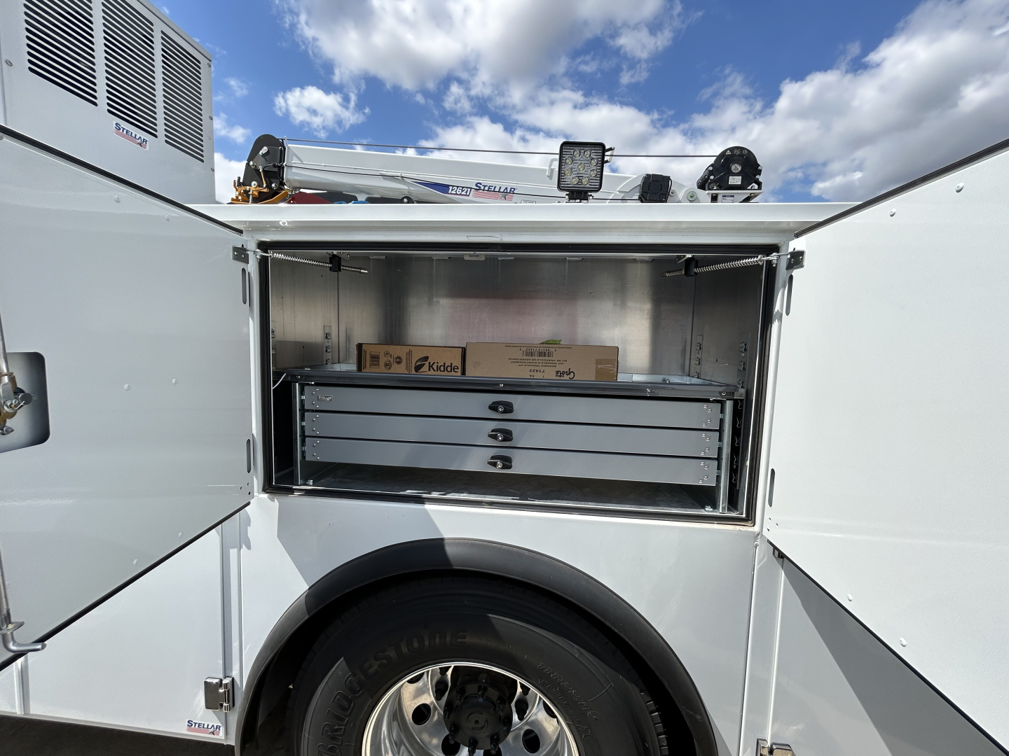 MD6 service body with open side compartment showing a set of drawers and storage boxes inside.