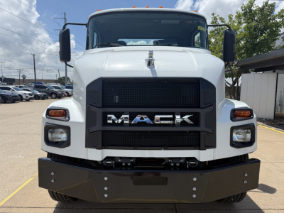 Front view of a white 2025 Mack MD6 truck showing large black grille with MACK lettering, headlights, and a heavy-duty front bumper.