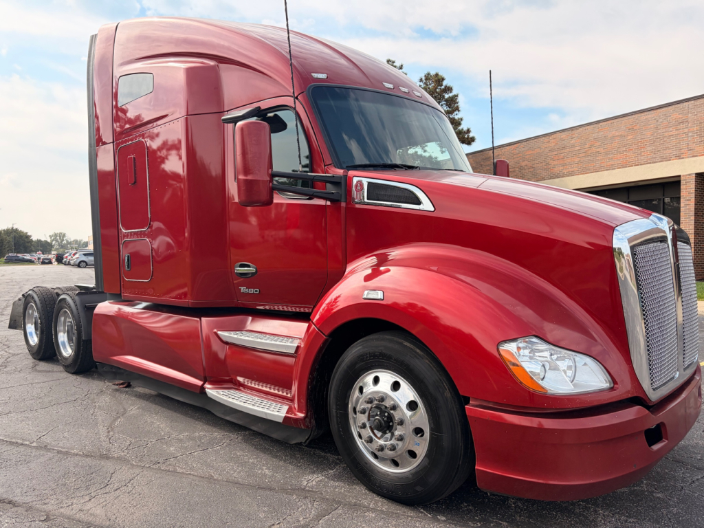 Kenworth T680 truck in red, side/front view showing sleeper cab, front grille, chrome wheel covers, and dual rear axles.