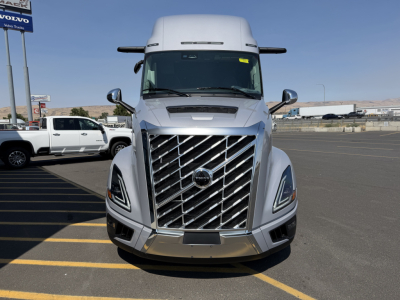 Front view of a silver Volvo VNL64T860 highway tractor showing distinctive diamond grille, large chrome bumper, and side mirrors.
