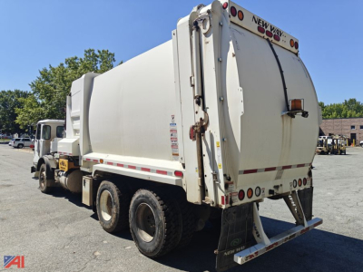 Rear and side view of a 2018 Autocar XPeditor Packer truck with a large hopper and rear doors labeled NEW WAY, showing dual rear wheels and towing hitch.