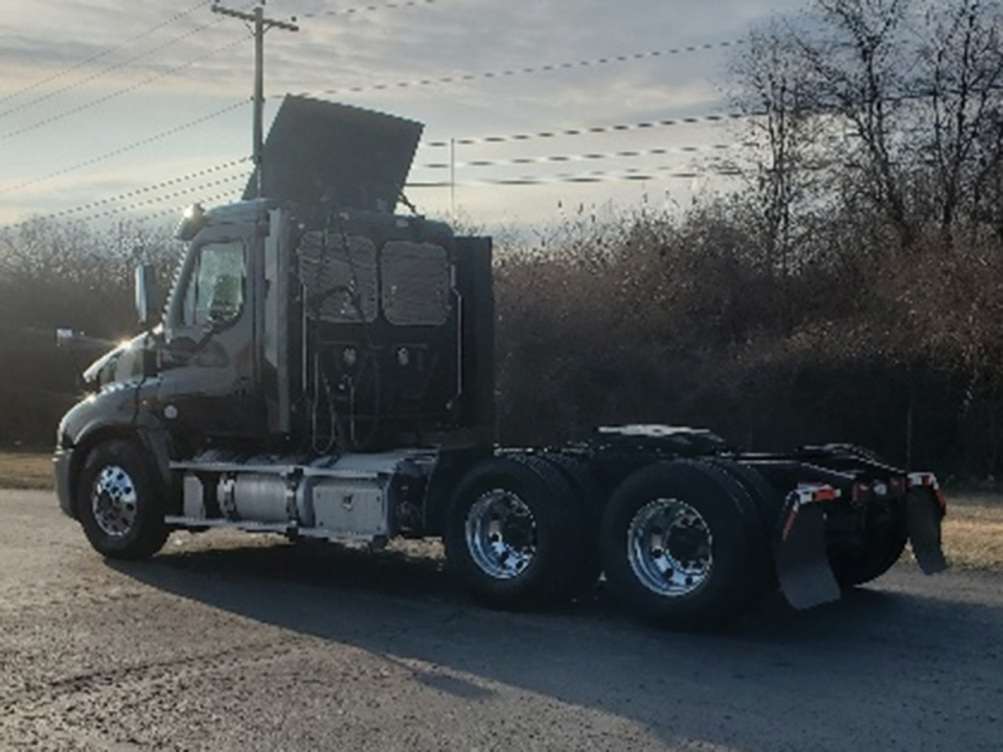 Freightliner Cascadia125 daycab truck rear three-quarter view showing sleeper cab, dual rear axles, and exposed chassis.