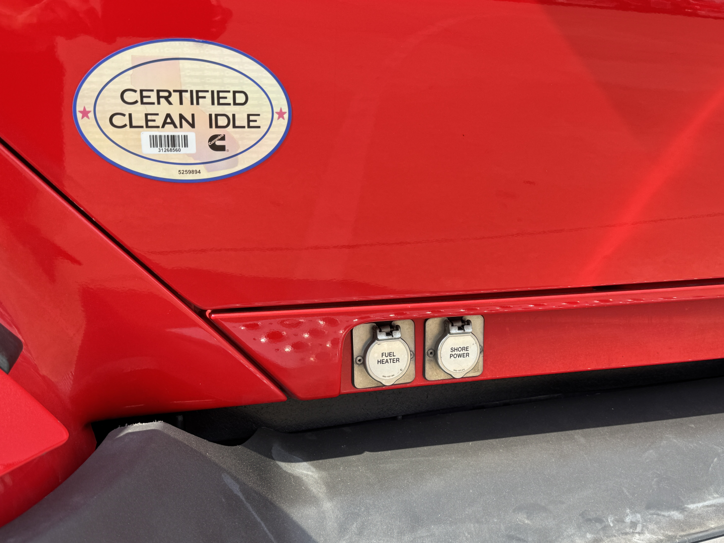 Kenworth T680 side panel showing two small switches labeled Fuel Tank? and Power? with a circular Certified Clean Idle sticker nearby.