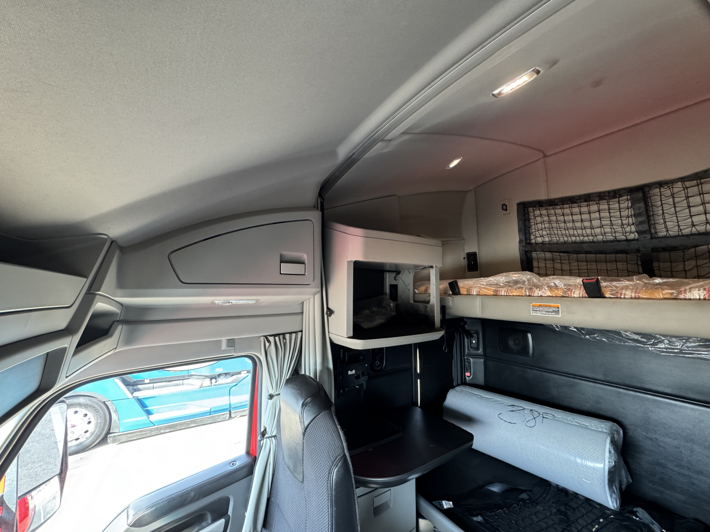 Kenworth T680 sleeper cab interior showing bunk area and storage shelves