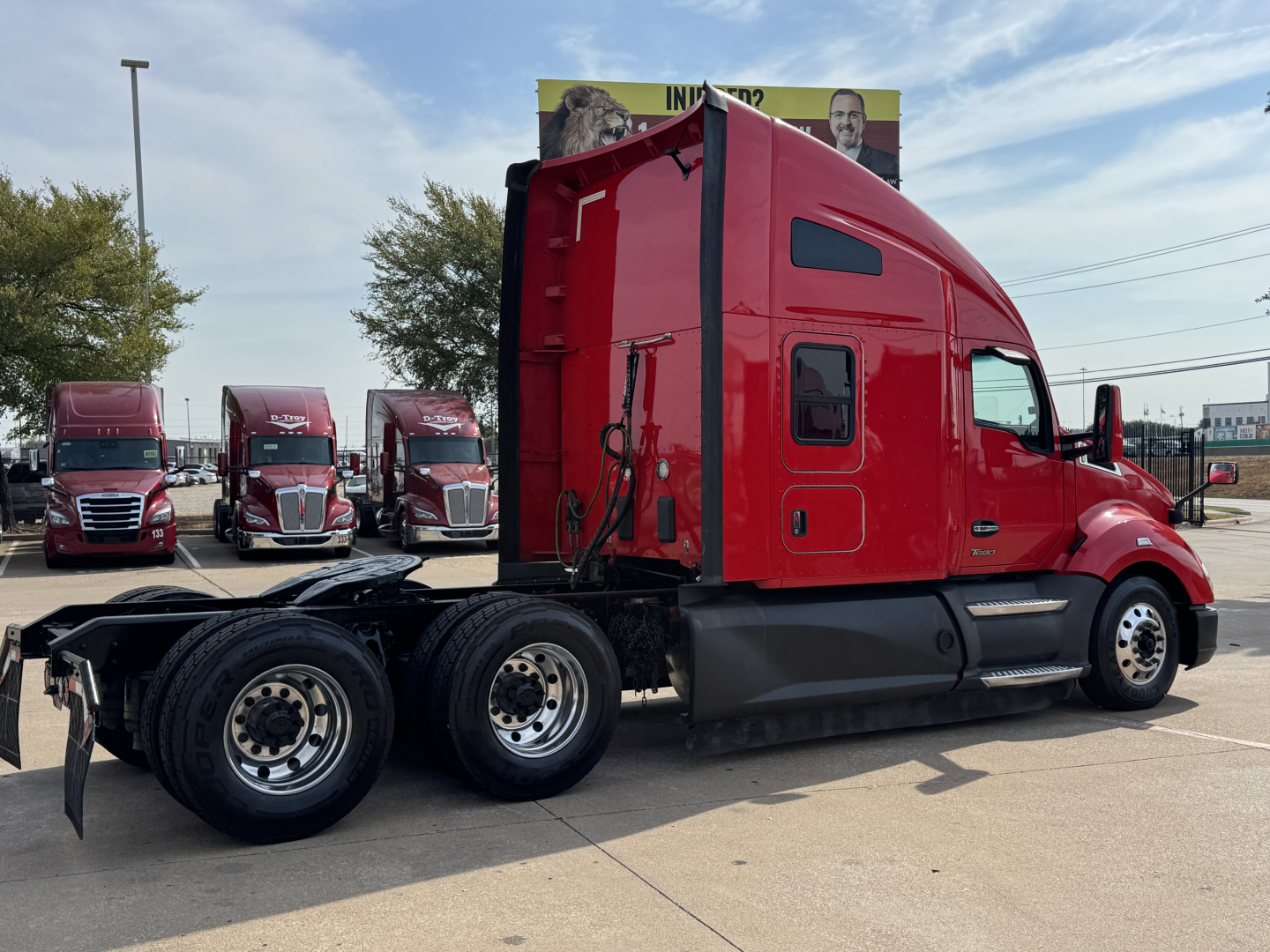 Kenworth T680 conventional sleeper truck side view showing red cab and black chassis.