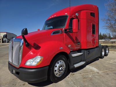 Kenworth T680 tractor in red, front left view showing cab, chrome grille, and dual rear axles.