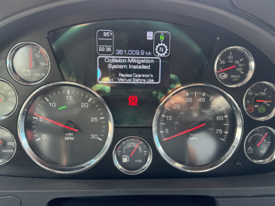 Kenworth T680 instrument cluster showing dashboard gauges and center display with 'Collision Mitigation System Installed' text.