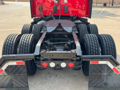 Kenworth truck rear chassis showing dual rear axles and fifth wheel mount with mud flaps and dual tires.