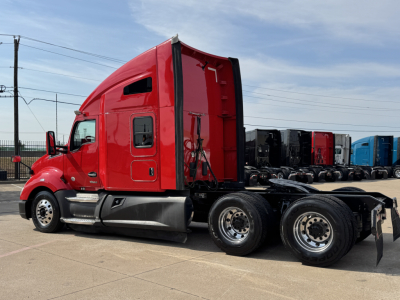Kenworth T680 truck tractor side profile showing red cab and dual rear axles with chrome fuel tanks and black chassis.