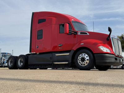 Kenworth T680 sleeper cab truck side view showing red exterior and dual rear axles.
