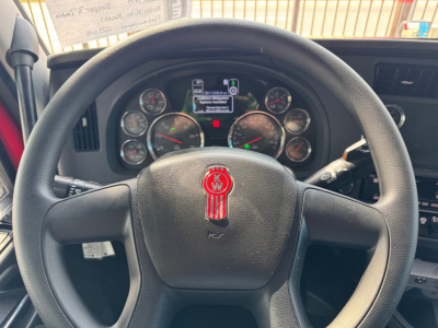 Kenworth T680 steering wheel and instrument cluster view with dashboard gauges and center display.
