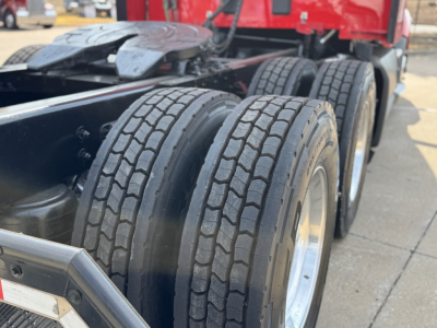 Kenworth T680 chassis with triple rear axles and tire tread visible.