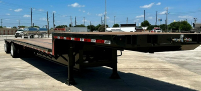 Drop deck trailer showing long flatbed with black frame and hydraulic support legs, 48-foot spread model, plate and hitch area visible.