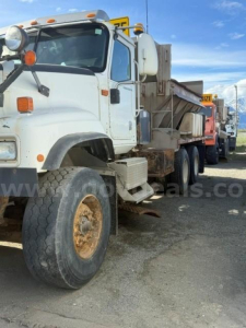 International 5500i heavy-duty plow truck side view showing front wheel, cab, and dump bed with rusted metal components.