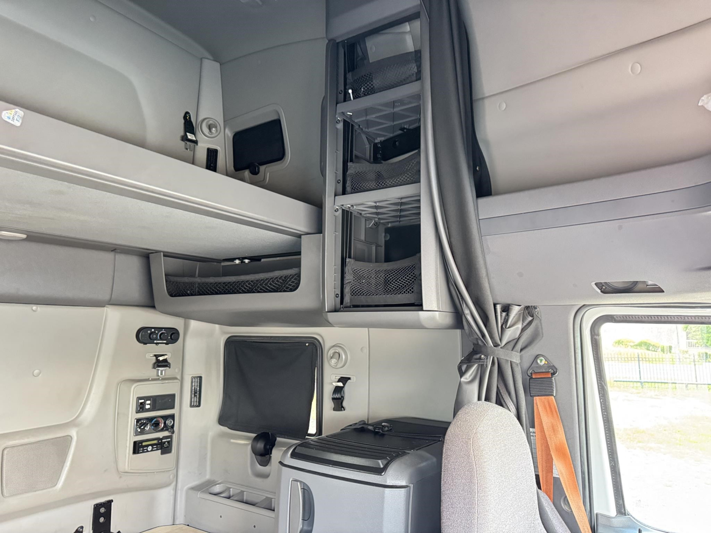 Cab interior of a 2020 International LT sleeper tractor showing bunk area and side controls.