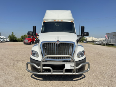 Truck front view of a white 2020 International LT conventional sleeper with a heavy-duty grille guard and running lights.