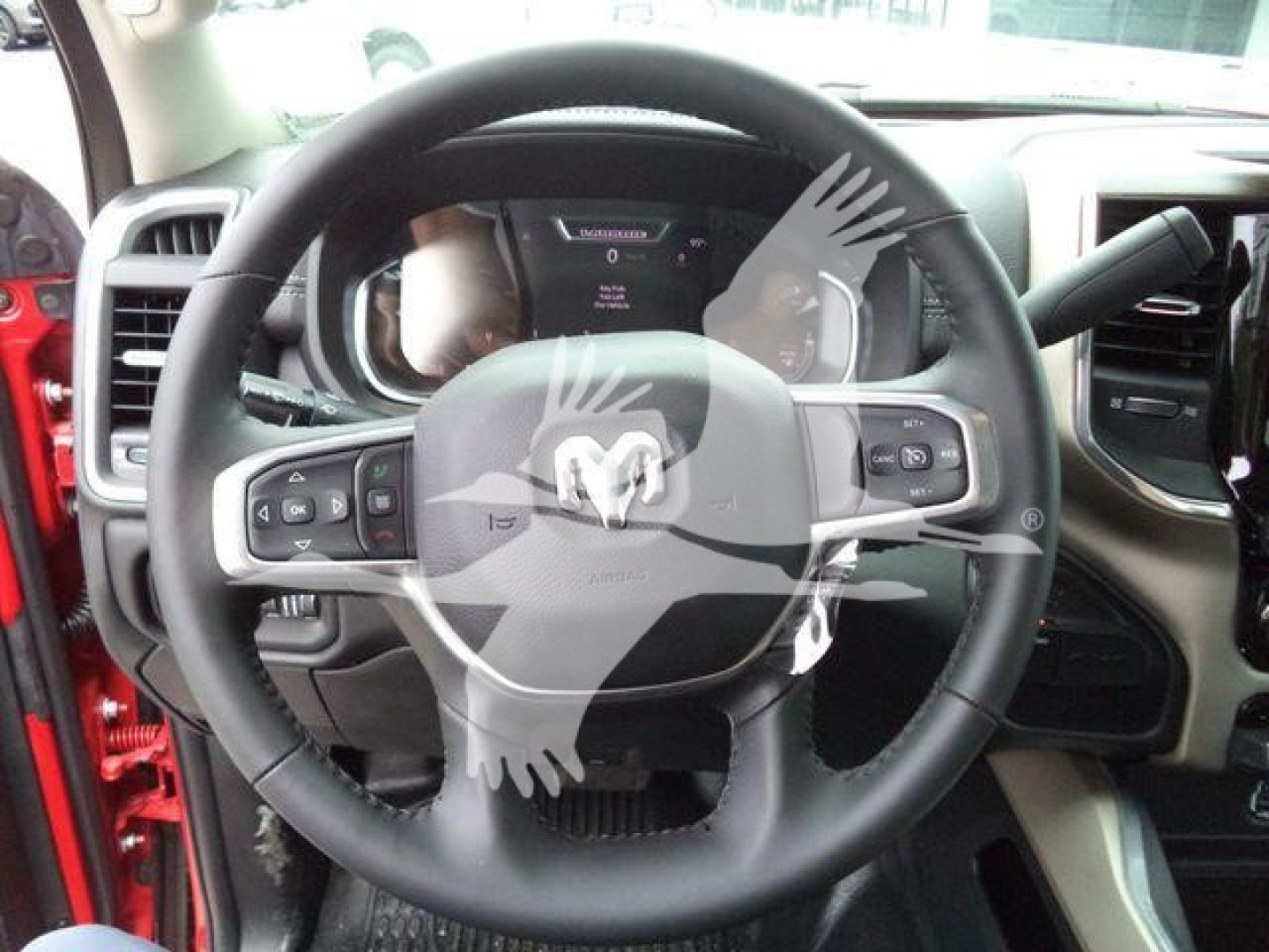 Ram steering wheel and dashboard inside 2024 Ram Laramie truck showing steering wheel controls and instrument cluster.