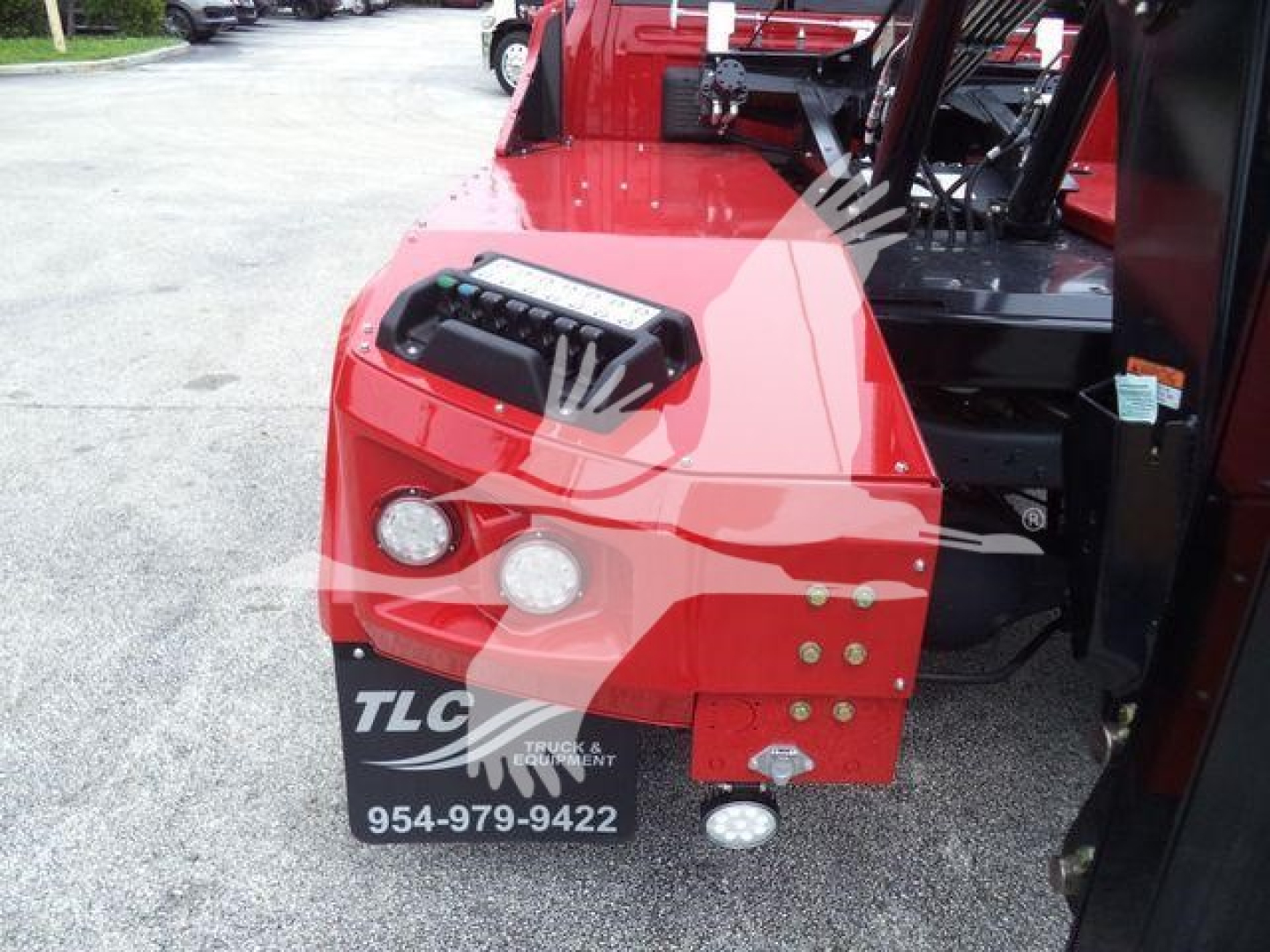 Truck front end with red winch-equipped bumper, dual round headlights, and TLC Trucks & Equipment logo plate visible; part of a Ram Laramie truck listing.