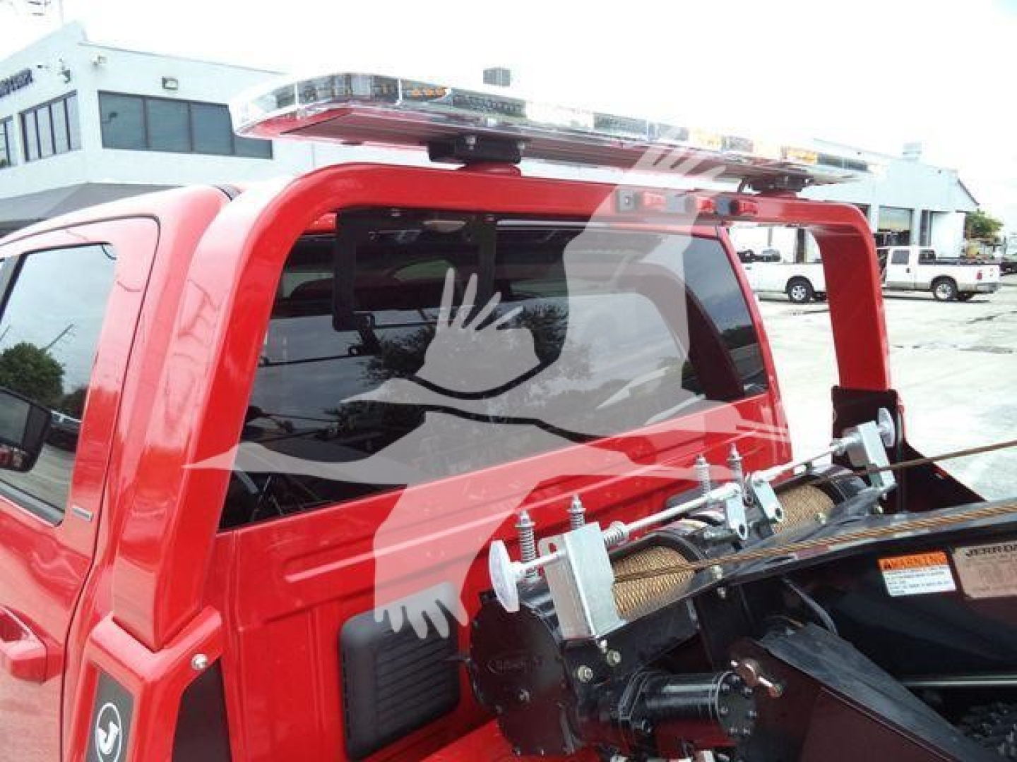Ram pickup winch-equipped truck rear window with rope/tow hitch and spare parts in bed area visible