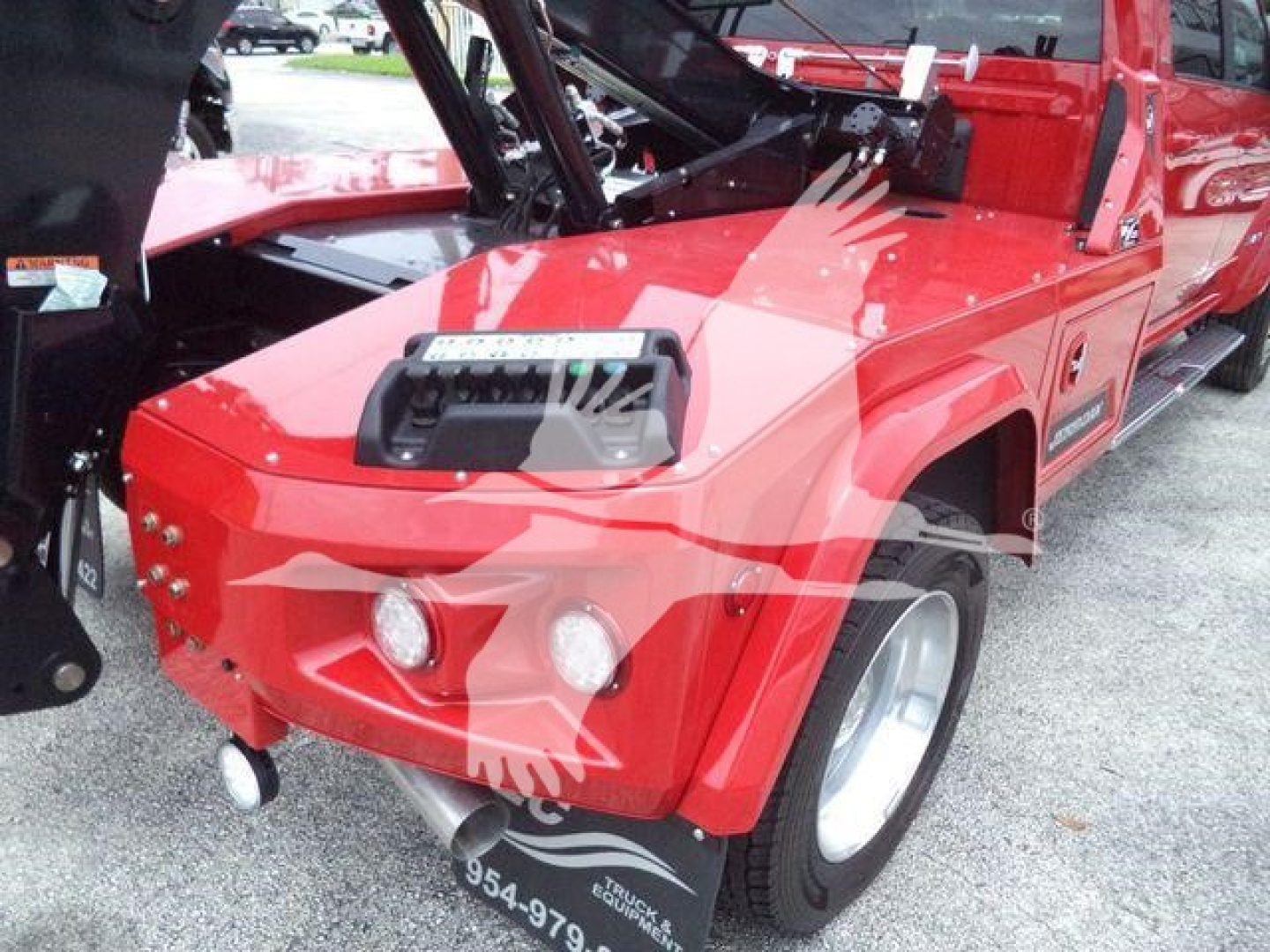 Ram truck front-left view showing winch-equipped red Ram pickup with open hood and exposed engine bay.
