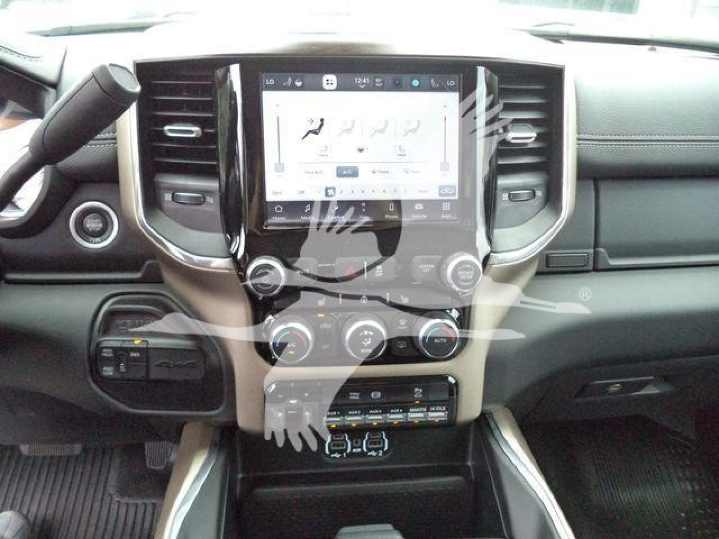 Ram truck interior showing large center touchscreen display and climate controls with steering wheel and dashboard visible.