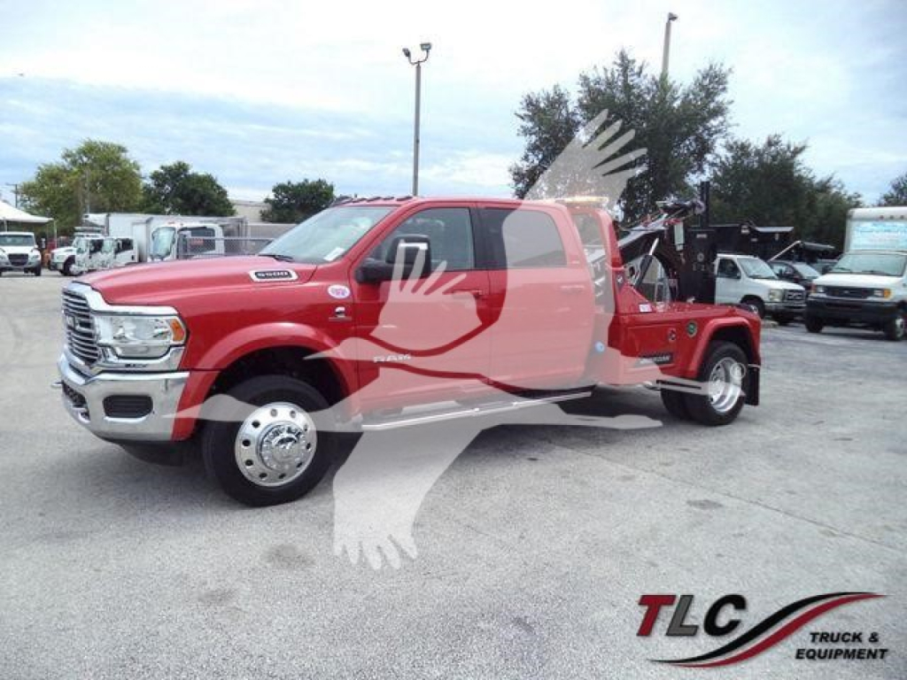 Ram 2500/3500 tow truck in red with crane bed and winch, front grille, truck cab, and dual rear wheels visible.
