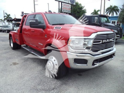 Red Ram 3500 heavy-duty tow truck in a dealership lot showing front grille and side steps.