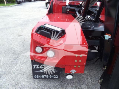 Truck front end with red winch-equipped bumper, dual round headlights, and TLC Trucks & Equipment logo plate visible; part of a Ram Laramie truck listing.