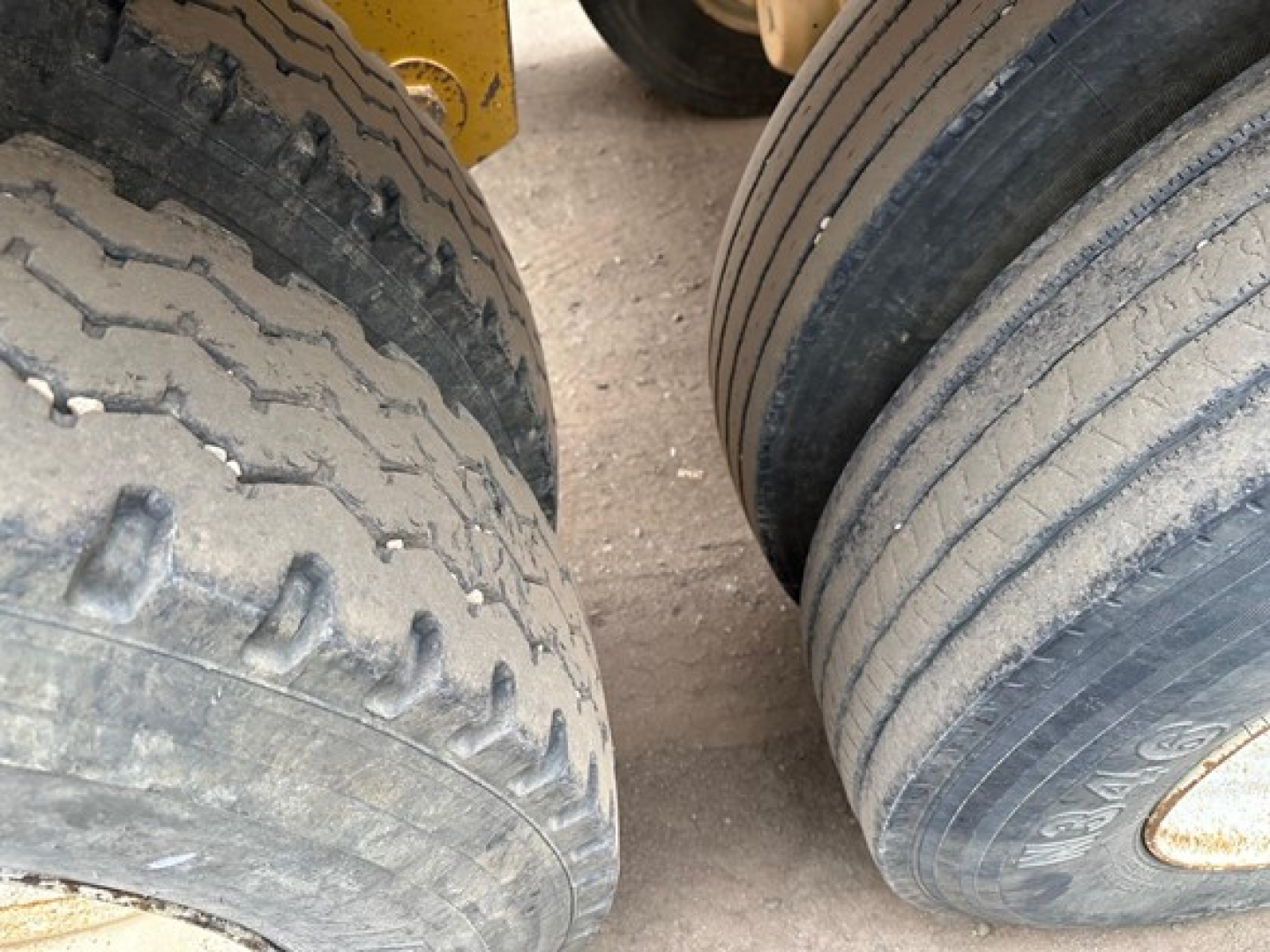 Trailer tires in view under a Load King Originator Bottom Dump showing heavy tread and dual-axle tires.