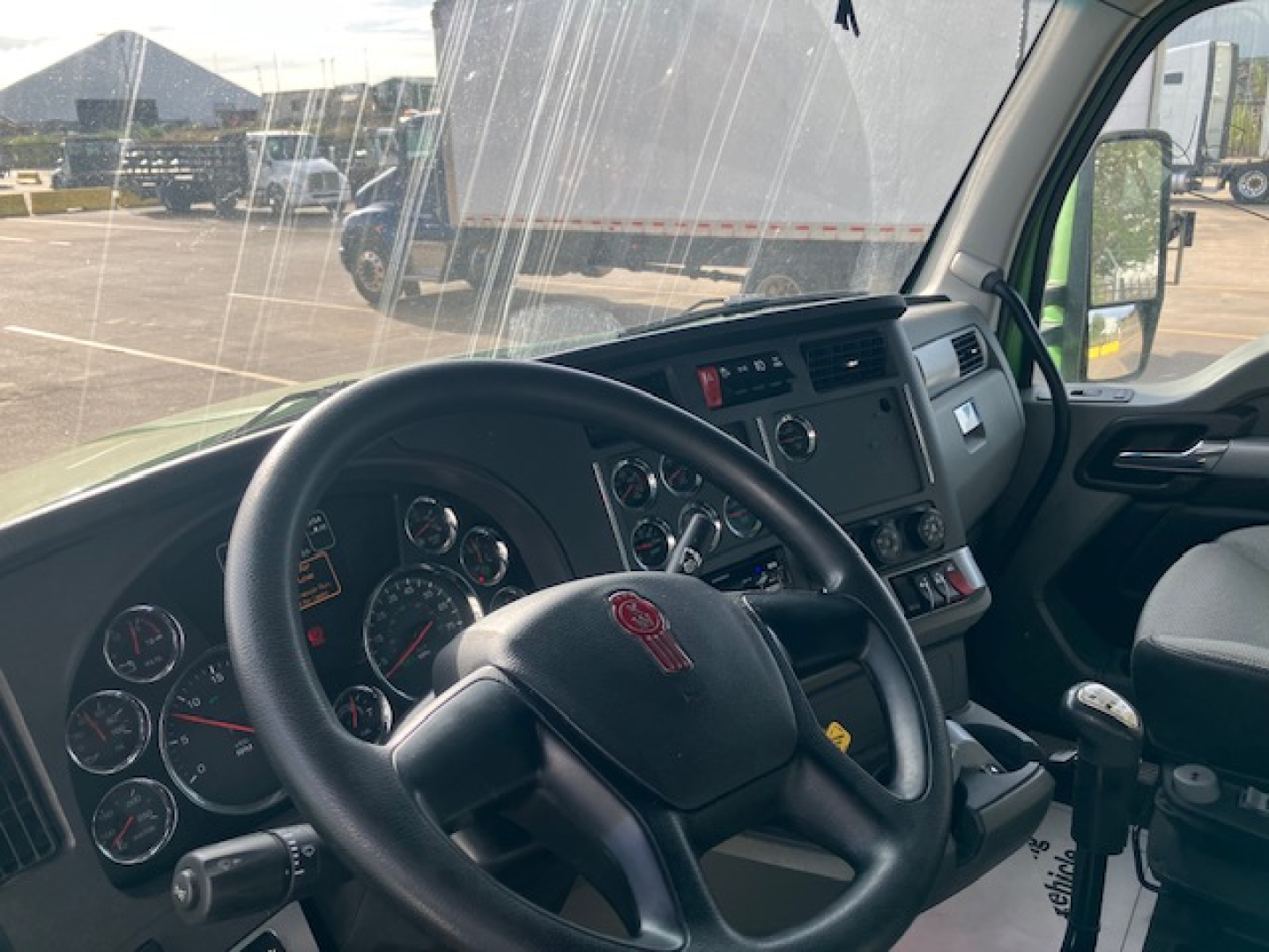 Kenworth T680 truck interior dash and steering wheel showing gauges and controls.